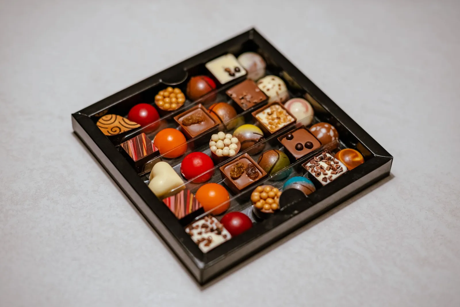 A delightful assortment of gourmet pralines and chocolates in a stylish box, perfect for gifting.